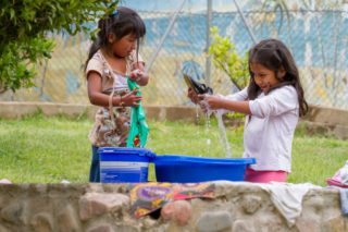 Kinder in der Aldea beim Waschen ihrer Schuhe. Ein Foto von 2012. Foto: SMMP/Ulrich Bock